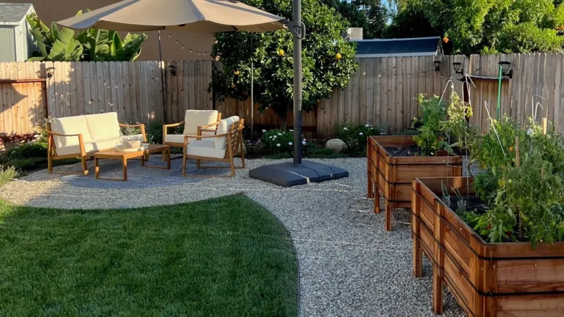 Raised bed garden and shaded sitting area and lush green lawn highlight this outdoor living area