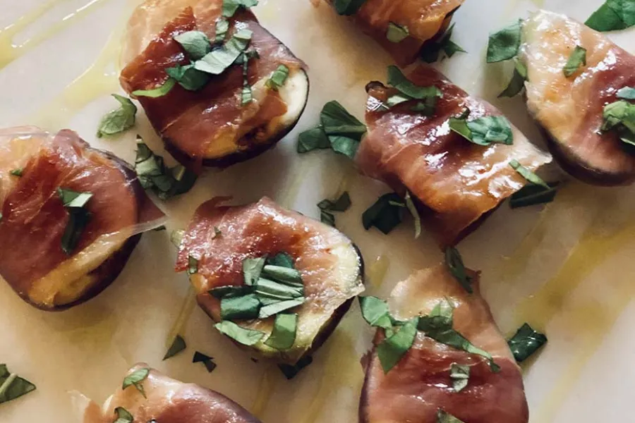 Fresh figs wrapped with proscitto, drizzled with honey and topped with fresh basil