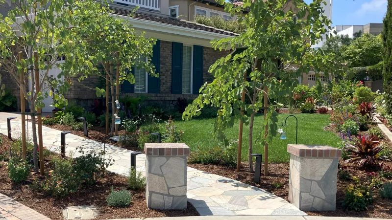 A lighted pathway and lush landscaping welcome you to the front door