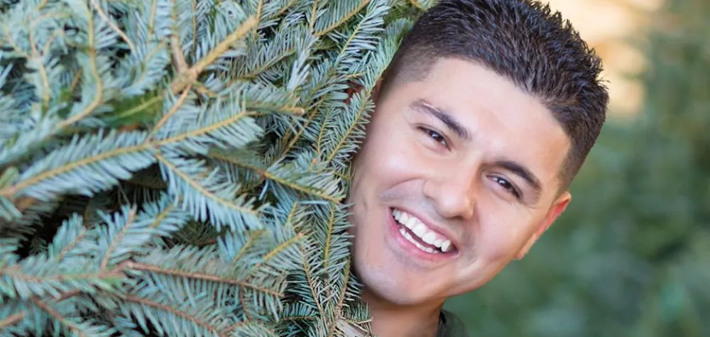 Armstrong associate holding Christmas tree